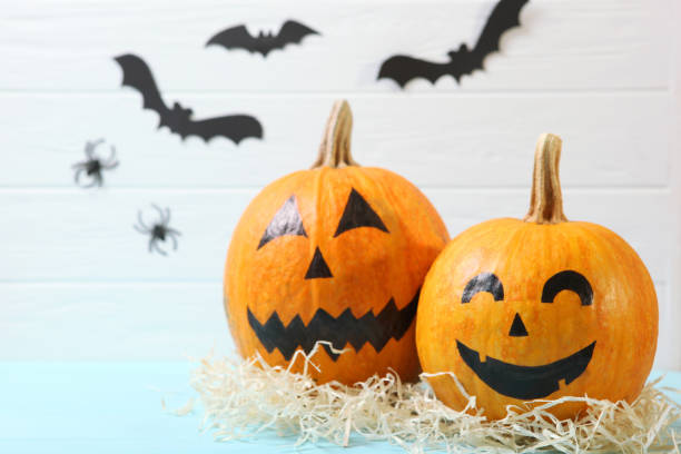 istock pumpkins with painted faces on a colored background for Halloween. 1279837174