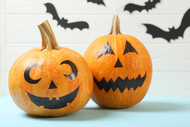 istock pumpkins with painted faces on a colored background for Halloween. 1279837215