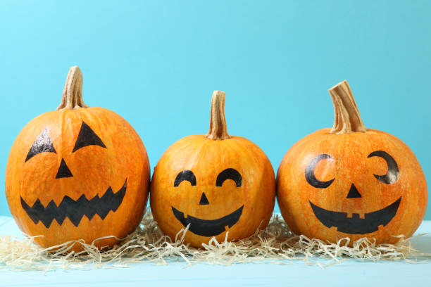istock pumpkins with painted faces on a colored background for Halloween. 1279837226