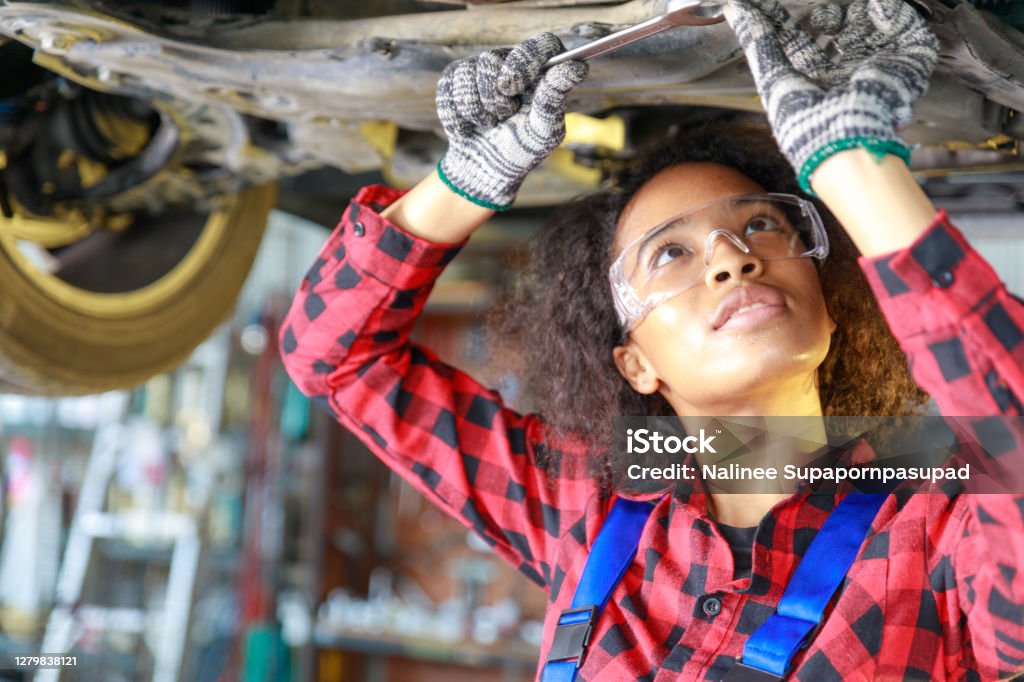 Female auto mechanic working at the repair shop. Auto Mechanic Stock Photo