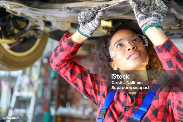 Female Auto Mechanic Working At The Repair Shop Stock Photo - Download Image Now - Auto Mechanic, Auto Repair Shop, Mechanic