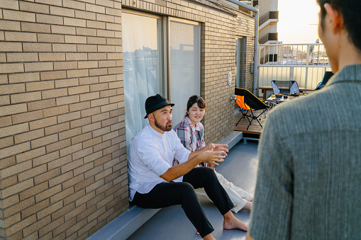 A group of friends are enjoying talking with each other at a rooftop party.