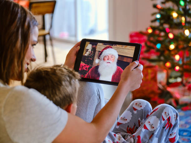 Father and Daughter Talking to Santa Claus on a Video Call A father and daughter, talking to Santa Claus on a computer video conference call. virtual event photos stock pictures, royalty-free photos & images