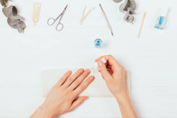istock Female hands apply nail polish next to self-manicure accessories 1279841547