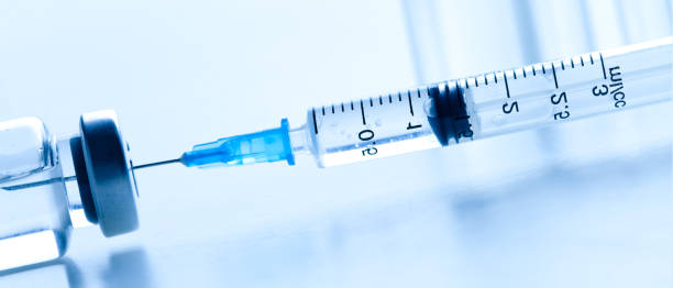 istock Medical syringe with a needle and a bollte with vaccine. 1279843079