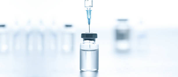 istock Medical syringe with a needle and a bollte with vaccine. 1279843383