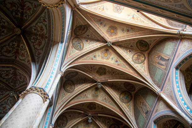 Beautiful vaulted ceiling of a church with colored old paintings