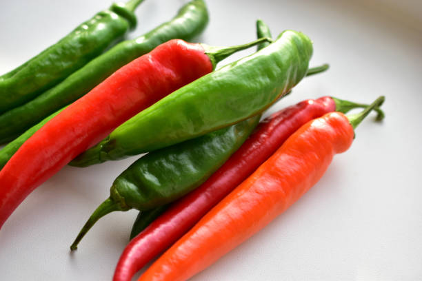 istock Green and red capsicum fruits on a white background 1279847771