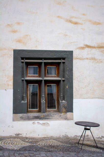 czarny okrągły stół na kamiennym chodniku przed starym ciemnym zabytkowym oknem. - slovakia ancient past architecture zdjęcia i obrazy z banku zdjęć