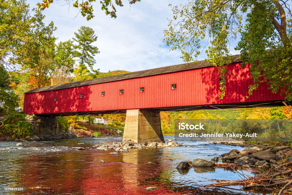 West Cornwall bridge over the Housatonic River A historic red covered bridge crosses the Housatonic River in West Cornwall, Connecticut on a sunny fall day. New England - USA Stock Photo