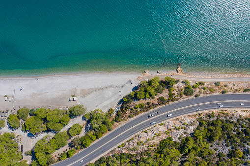 Aerial view of sea and curved asphalt road. Taken via drone.