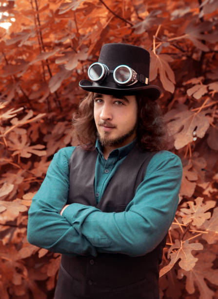Young man wearing hat in nature Young gentleman with top hat outdoors steampunk fashion stock pictures, royalty-free photos & images