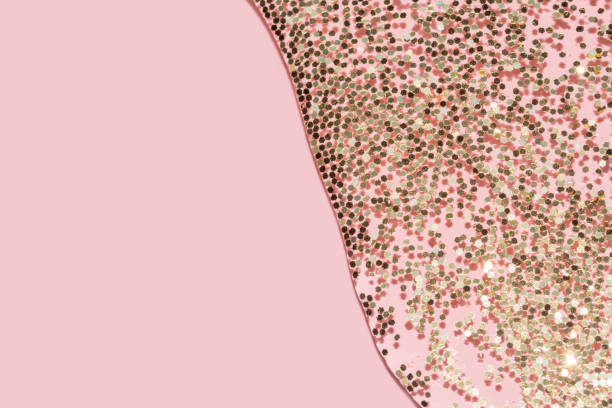 istock transparent liquid with gold glitter pouring over a pastel pink background 1279854412