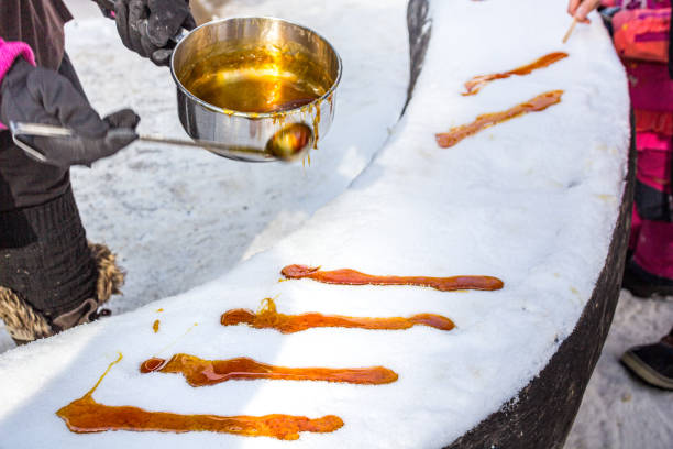 taffy de sucre d’érable sur la neige à la cabane à sucre - maple syrup sugar shack photos et images de collection