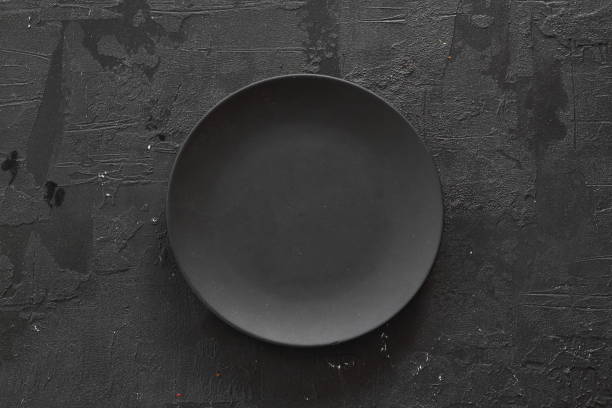 istock Empty black slate plate on dark stone table. Food background for menu, recipe. Table setting. Flatlay, top view. Mockup for restaurant dish 1279856321