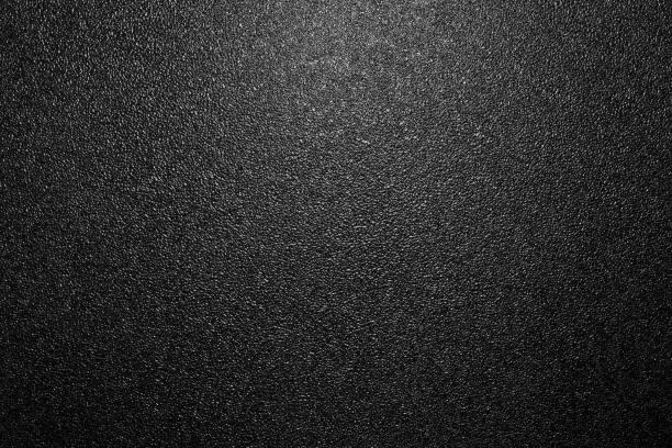 Photo of dark background of hammered powder paint coating on flat sheet steel surface