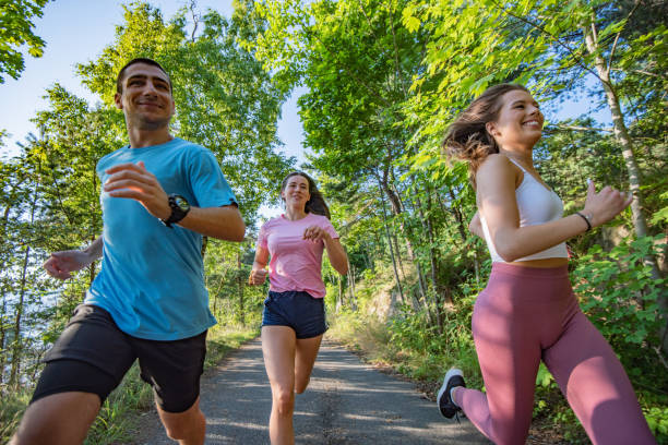 istock Three young people jogging together in nature. 1279857010