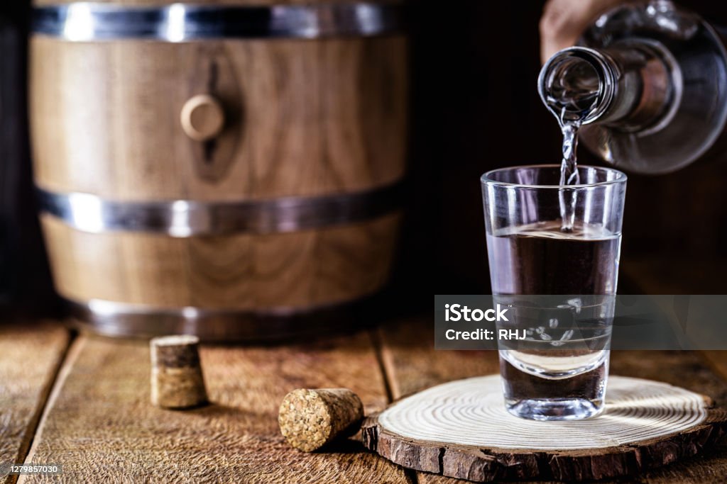 glass of alcoholic drink with bottle, hand filling glass. Image of bar, pug, spirits of the type Aguardente, such as tequila, rum, vodka or cachaça Cachaça Stock Photo