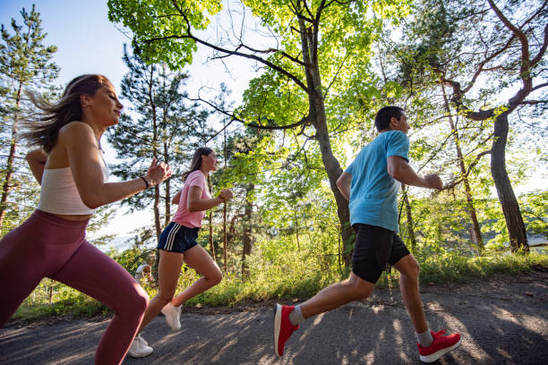 istock Three young people jogging together in nature. 1279857281