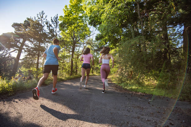 istock Three young people jogging together in nature. 1279857598