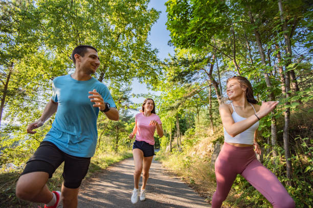 istock Three young people jogging together in nature. 1279858260