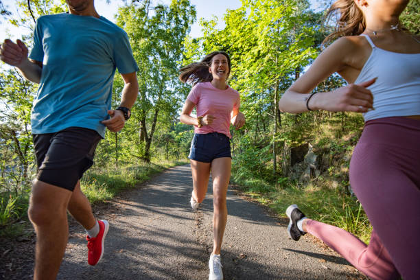 istock Three young people jogging together in nature. 1279858783
