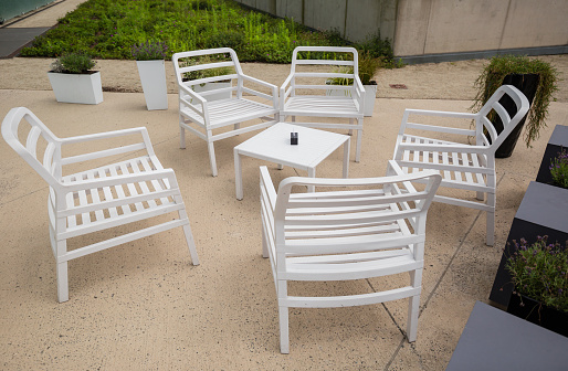 Outdoor furniture in garden, white chairs with table in cafe