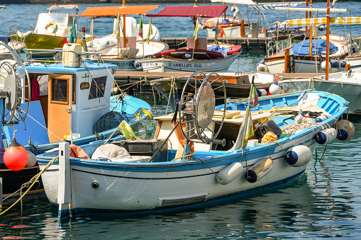 Capri, Italy - August 2019: Small fishing boat tied up with other boats in the harbour on the Isle of Capri.