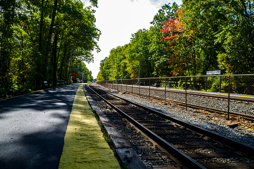 A typical suburban commuter rail station showing the effects of the pandemic with most people working from home.  Shot in Wellesley, MA, a suburb of Boston. Illustrates loneliness, emptiness, and an overall lack of activity.