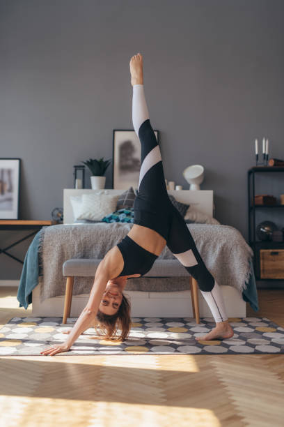 istock Three legged dog pose. Fit woman doing stretching yoga exercise 1279861724