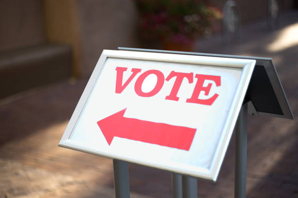 istock Sign at Polling Place with Red Arrow Reading: VOTE 1279862462