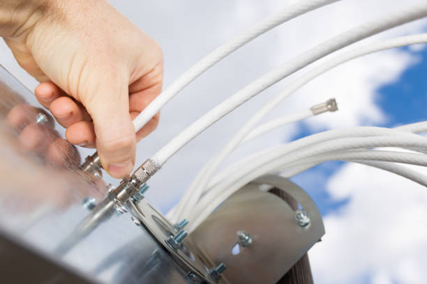 installation antenna. Hand connecting cables Man's hand connecting Cable to 4G antenna close up with sky on background. installing tv stock pictures, royalty-free photos & images