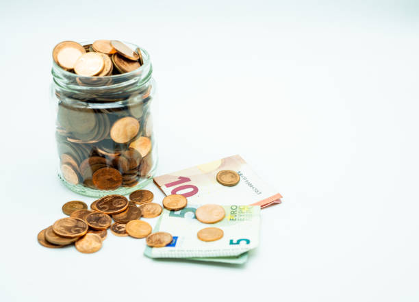 istock glass jar with coins and bills on white background 1279864338