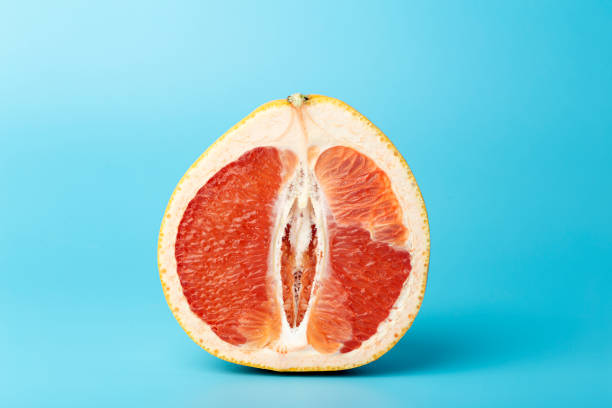 istock Grapefruit minimal erotic concept. Half a juicy grapefruit close up on a colored background. 1279867920