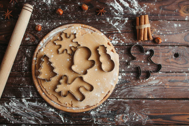 masa de pan de jengibre con formas de tema navideño - cortador de masa fotografías e imágenes de stock