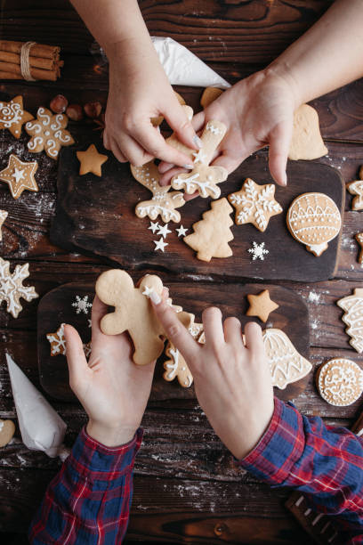 istock Friends decorating christmas gingerbread cookies 1279868123