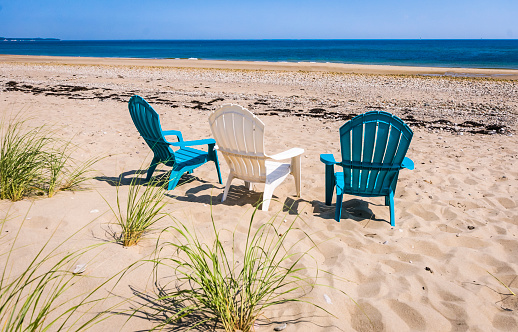 Romantic sea scene at white beach with wicker beach chair at summer sunny day in north Germany