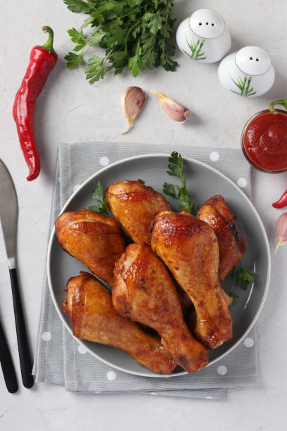 istock Roasted chicken drumsticks in honey and soy sauce on grey plate, top view. Vertical format. 1279874814