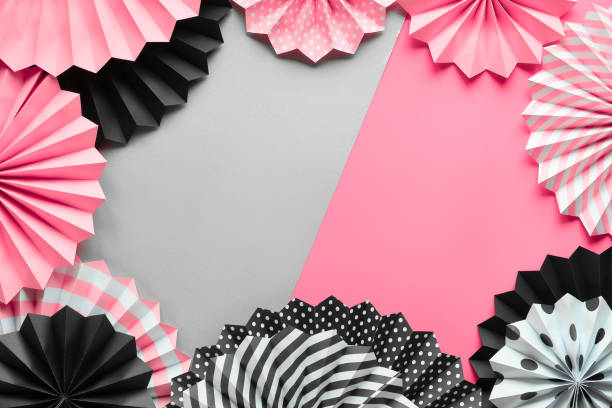 istock Vibrant frame with folded paper fans on black, pink and white on two tone background 1279878185