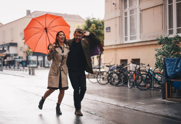 istock Couple running down the street while it rains 1279879092