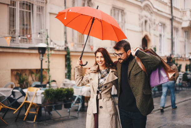 istock Young couple under umbrella walking 1279879119