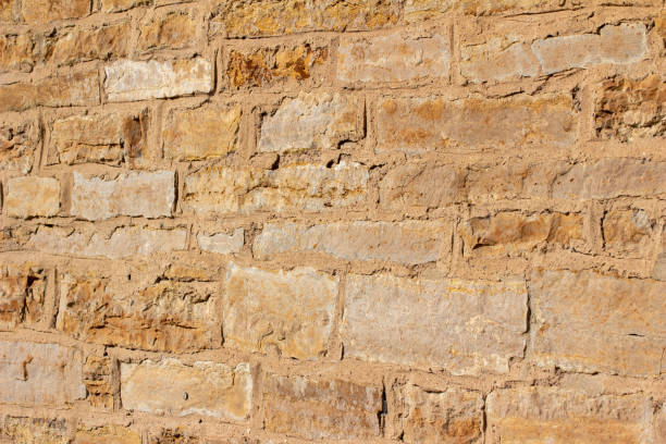 istock Antique golden brown stone wall background with rough texture 1279884584