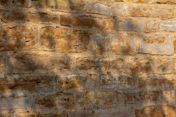istock Antique golden brown stone wall background with rough texture 1279884688