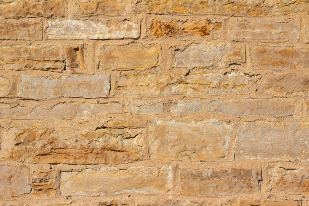 istock Antique golden brown stone wall background with rough texture 1279884695