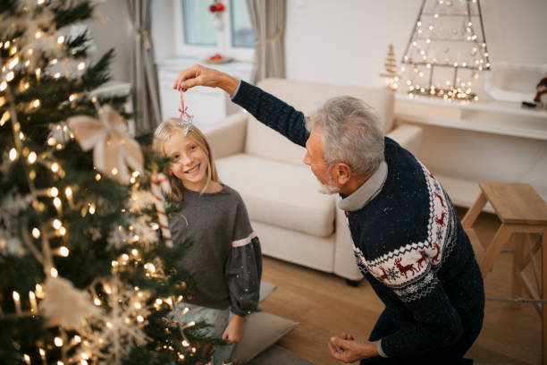istock Happy family decorating a Christmas tree with ornaments 1279885697