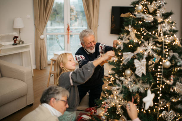 istock Happy family decorating a Christmas tree with ornaments 1279885698
