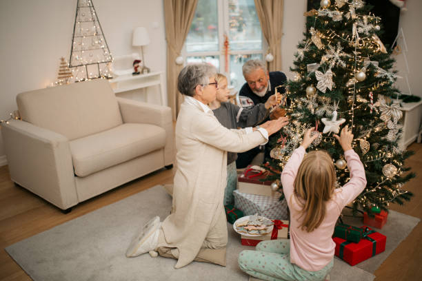istock Happy family decorating a Christmas tree with ornaments 1279885699