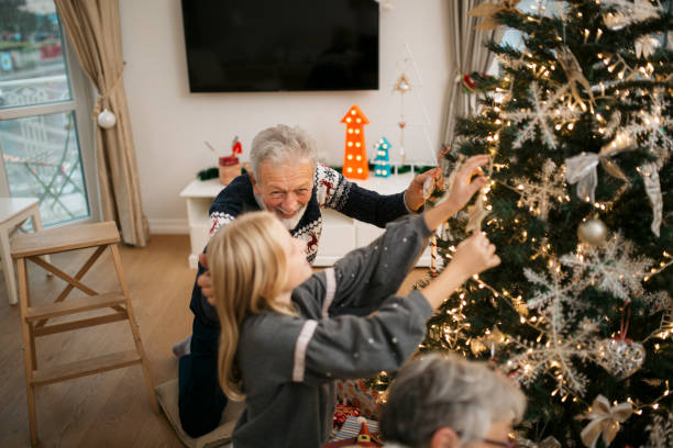 istock Happy family decorating a Christmas tree with ornaments 1279885700