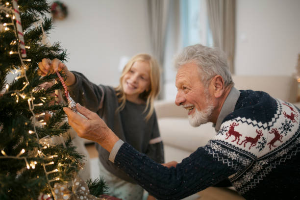 istock Happy family decorating a Christmas tree with ornaments 1279885734