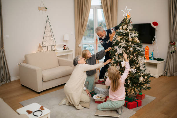 istock Happy family decorating a Christmas tree with ornaments 1279885759